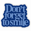 A die-cut sticker with the phrase 'Don't forget to smile' in light blue serif lettering on a dark blue background, shown on a plain white backdrop.