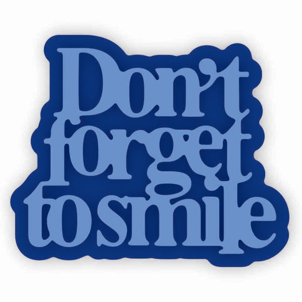 A die-cut sticker with the phrase 'Don't forget to smile' in light blue serif lettering on a dark blue background, shown on a plain white backdrop.