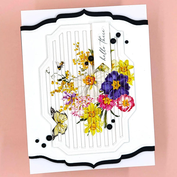 A handmade greeting card featuring a white embossed background with a central floral and butterfly illustration. The card has a black scalloped border and is photographed against a solid pink background.