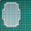 A clear acrylic or plastic die-cut template with a decorative border and vertical slat pattern, placed on a green cutting mat with grid lines and measurements.