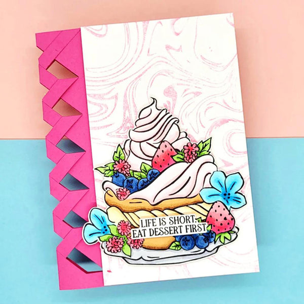 A handmade greeting card featuring a colorful illustration of a dessert with strawberries, blueberries, and flowers, with the text 'LIFE IS SHORT. EAT DESERT FIRST!'.