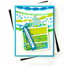 A handmade birthday card featuring a stylized layered cake with green and blue layers, a blue ribbon bow, and a white number 2 candle topper, shown on a white background with black and white backing cards.