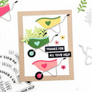 A handmade greeting card featuring three colorful hand-drawn wheelbarrows with green leaves and hearts, set on a white background with a kraft paper border. The center wheelbarrow has a black banner that reads 'THANKS FOR ALL YOUR HELP'.
