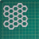 A silver metal hexagonal grid cutter or stencil template made of interlocking hexagons, placed on a green cutting mat with grid lines.