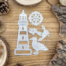 A set of silver metal cutting dies shaped like a lighthouse, a compass rose, an anchor, and a seagull, displayed on a rustic wooden background with natural wood slices and pinecones.