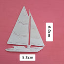 A silver metal sailboat cutout on a pink background, with white measurement labels showing 6.0cm height and 5.3cm width.
