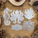 A set of five metal die-cutting templates featuring a seahorse, octopus, and coral reef designs, arranged on a rustic wooden background with pinecones and wood slices.