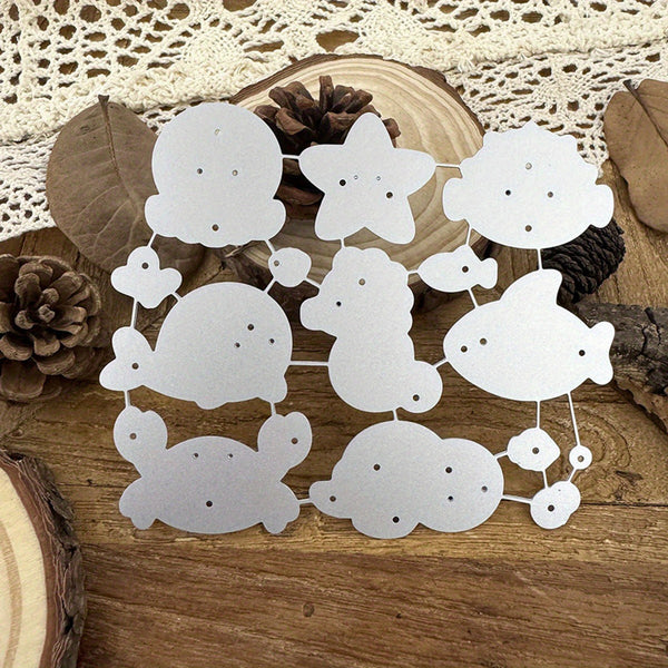 A set of white paper cutout shapes with small holes, arranged on a rustic wooden surface with pinecones, wood slices, and a lace cloth background.