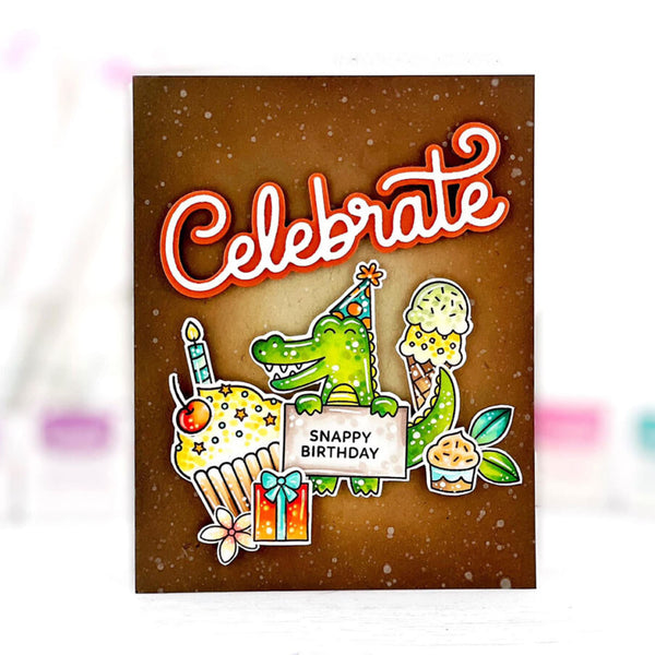 A square birthday card with a brown glittery background and the word 'Celebrate' in large red-and-white script. Below, a green cartoon alligator wearing a party hat stands beside cupcakes and a gift, with a sign reading 'SNAPPY BIRTHDAY.