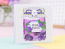 Decorative card with purple berries and a white flower on a colorful background