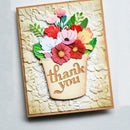 A handmade square greeting card featuring a 3D floral arrangement in a beige pot with the words 'thank you' in script, photographed on a light gray textured background.