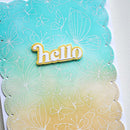 A close-up of a handmade greeting card featuring a scalloped edge, white butterfly and floral line engravings, a turquoise-to-cream gradient background, and a central 'hello' embellishment.