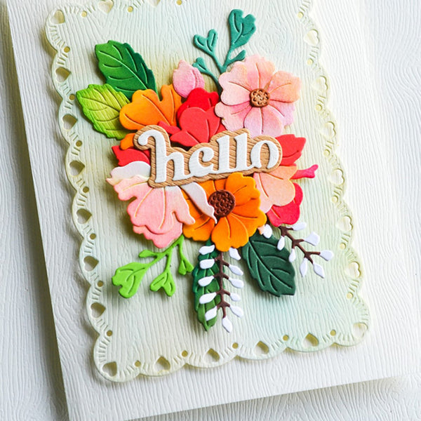 A handmade greeting card featuring a scalloped cream border and a colorful layered flower bouquet with a wooden-style 'hello' message in the center, photographed on a white textured background.