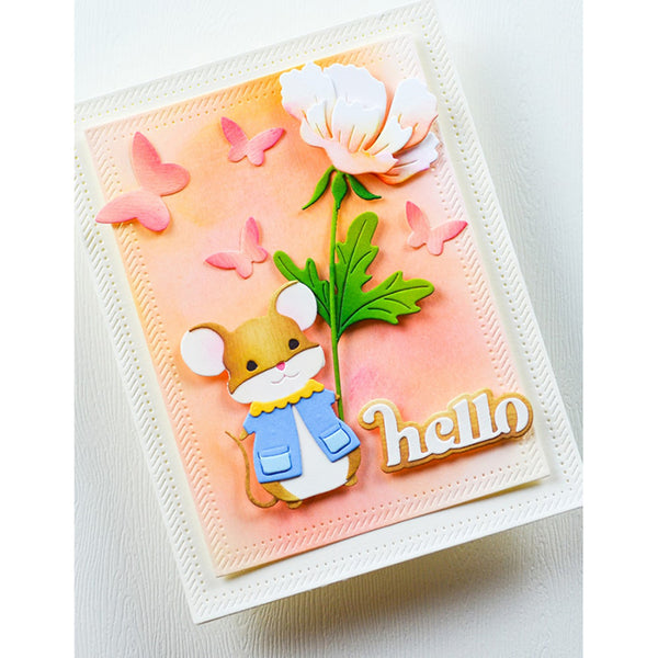 A handmade greeting card featuring a cute cartoon mouse wearing a blue jacket, a large white flower with green leaves, pink butterflies, and the word 'hello' in gold. The card has a peach watercolor background and is mounted on a white textured cardstock.