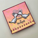 A square handmade greeting card with a pink and yellow gradient background, featuring two cartoon dogs kissing, a heart, and the German text 'Zur Hochzeit' on a light neutral surface.