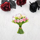 A die-cut sticker of a bouquet of pink tulips and white lilies tied with an orange band, displayed on a textured white background with decorative red and black roses in the corners.