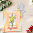 A handmade greeting card with a floral window illustration and the text 'HAVE A lovely day' is displayed on a light wood surface alongside a silver floral die-cutting template, green eucalyptus leaves, and red berries.