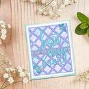 A handmade greeting card with the phrase 'best day ever' in turquoise script over a lavender and light blue lattice pattern, decorated with butterfly embellishments and small rhinestones, displayed on a light wood background with baby's breath flowers and mint leaves.
