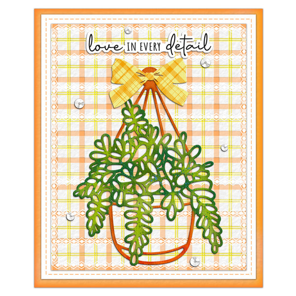 A handmade greeting card featuring a green hanging plant with a yellow plaid bow, set against a peach and yellow plaid background with the text 'love IN EVERY detail'.