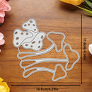A metal die-cut craft template shaped like mushrooms and stems, shown on a wooden surface with printed dimension lines indicating 11.6 cm by 10.