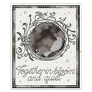 A square greeting card or art print featuring a decorative silver-toned ornamental frame with a bird perched inside a snowy circular scene. The card has a textured off-white background, silver script text reading 'Together in bloom and quiet,' and small scattered gold foil accents.