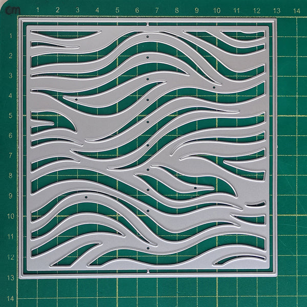 A square clear acrylic cutting mat with an intricate wavy pattern, displayed on a green gridded cutting mat. The mat features a double border and is shown from a top-down perspective.