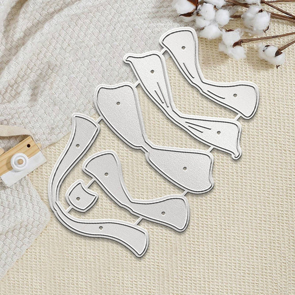 A set of white plastic or acrylic nail art stamping dies with silver metal cutting edges, arranged on a textured cream fabric background with cotton stems and a small wooden tool as props.
