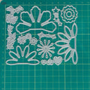 A set of clear plastic craft die-cutting templates featuring floral, leaf, and heart shapes, displayed on a green cutting mat with grid lines.