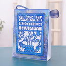 A blue and white layered carded gift bag with a ribbon, featuring a laser-cut 'BROTHER HAPPY Birthday' design with stars, balloons, and a birthday cake, displayed on a blue surface.