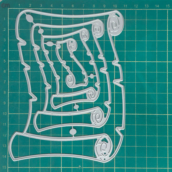 A clear plastic cookie cutter with an intricate scroll and loop design, displayed flat on a green cutting mat with grid lines.