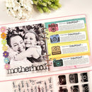 An open ring-bound scrapbook or journaling planner page displayed on a light background with flowers and a decorative sheet of camera-themed stickers below. The page includes a black-and-white photo of a woman and child, colorful camera illustrations, handwritten text, and the word 'motherhood' at the bottom.