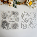 Clear stamp set and metal die set for crafting, featuring floral and quote designs, displayed on a white background with dried flowers as props.