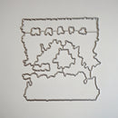 A metal die-cut craft cutting template with a rustic, wavy border and a central floral motif, displayed on a clean white background.