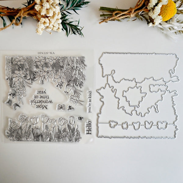A flat-lay product photo of a clear acrylic stamp set and matching metal dies on a white background, styled with dried flowers at the top.