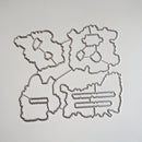 Four metal die-cut craft templates with irregular organic shapes and internal cutout lines, arranged on a plain light background.
