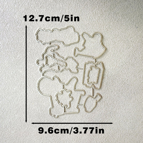 A set of metal die-cut craft templates arranged on a textured off-white background, with black measurement lines and text indicating dimensions of 12.7cm/5in vertically and 9.