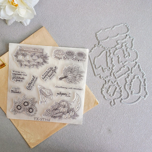 Clear stamp sheet and matching metal die set for autumn harvest-themed stamp designs, displayed on a neutral gray background with a kraft paper envelope and a white flower as props.