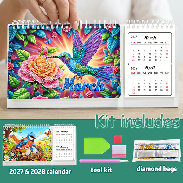 A colorful spiral-bound diamond painting calendar shown open, with a hand holding the top edge. The cover features a vibrant hummingbird and flower design with the word 'March' and monthly calendar pages visible on the right.