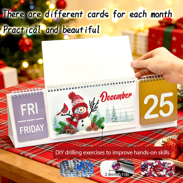 A tabletop calendar with a spiral-bound page turned open to a Christmas snowman illustration and the date December 25. A hand is holding the right side of the calendar.