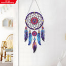 Colorful dreamcatcher wall decoration on a white wall with a chair and table in the background.
