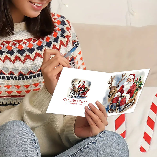 A person sitting indoors holds an open Christmas greeting card. The card shows Santa Claus illustrations and the words 'Colorful World.