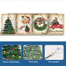 Four Christmas-themed diamond painting canvas designs displayed on a stand, featuring a green Christmas tree, Santa Claus, a green wreath with ornaments, and a red pickup truck with 'Merry Christmas' text. Below, three inset images show close-ups of the colorful beads, clear print quality, and a hanging pendant.