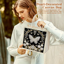 Woman holding a pearl-decorated canvas bag with butterfly design