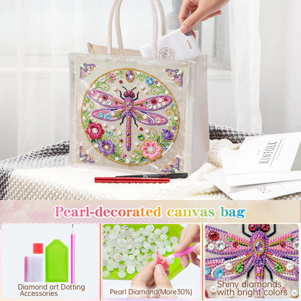 A clear canvas tote bag decorated with a colorful embroidered dragonfly and surrounded by faux pearls, shown with a hand placing a white item into its handle. The image includes text overlays describing the product and three small detail panels at the bottom showing dotting accessories, pearl diamonds, and a close-up of the dragonfly design.