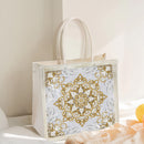 Decorative gift bag with gold and white pattern on a light background