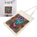 An off-white canvas tote bag with a large, colorful, intricate owl illustration printed on the front. A smaller inset image in the top-left corner shows the tote bag being worn by a person, demonstrating its use.