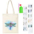 A canvas tote bag with a colorful dragonfly design, shown alongside a dragonfly painting kit containing paint, a brush, and multiple clear plastic packets of embellishments on a white background.