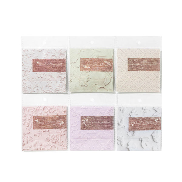 Set of six textured cards with embossed designs and text on a white background