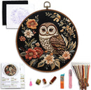 Embroidery hoop with owl and floral design, including thread and tools on a white background