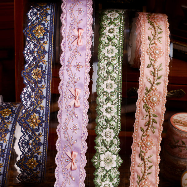 Four decorative ribbons with floral and bow designs on a wooden surface.